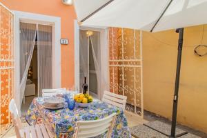 uma mesa com uma taça de fruta e um guarda-chuva em La Spiaggetta em Porto Azzurro