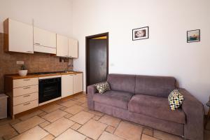 ein Wohnzimmer mit einem Sofa und einer Küche in der Unterkunft CASA LAPILLI in Polignano a Mare