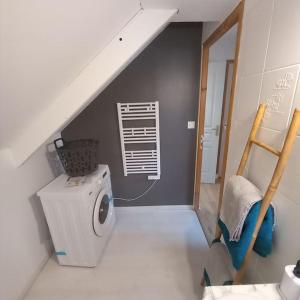 een kamer met een wasmachine en een trap bij gîte le petit roussel in Putanges