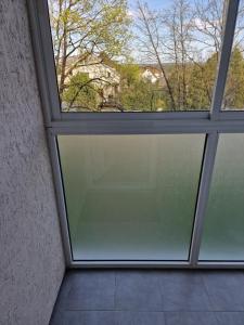 eine Glasschiebetür in einem Zimmer mit Fenster in der Unterkunft Butas in Kaunas