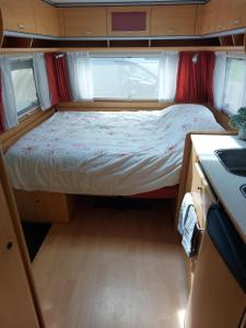 un piccolo letto nel mezzo di una piccola camera di Nikita caravane ad Aywaille