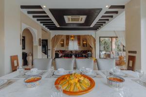 Villa Nelya في مراكش: طاولة طعام مع وعاء من الفواكه عليها