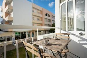 a wooden table on the balcony of a building at Blife Allya private rooms in Faro +14 photos