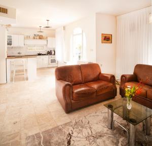 a living room with two brown leather couches and a table at Exclusive Jerusalem Villa in Jerusalem