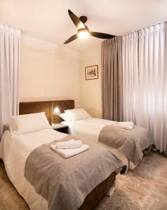 Exclusive Jerusalem Villa في Giv‘ot Mordekhay: غرفة نوم بسريرين ومروحة سقف