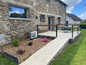 a stone house with a deck and a patio at Gite Varagnac in Saint-Cyr-les-Champagnes