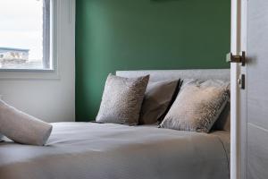 a bed in a room with a green wall at Cross Street Suites by DH ApartHotels in Peterborough