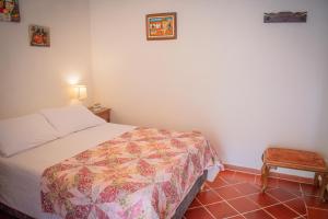 una piccola camera con letto e sedia di alojamiento JAW a Villa de Leyva