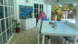 un comedor blanco con mesa y piscina en Villa Del Mar, en Las Terrenas