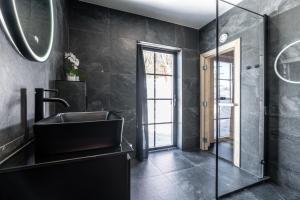 uma casa de banho preta com um lavatório e um espelho em Idre Sky Mountain Lodge- Ski in Ski out em Idre