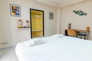 een witte slaapkamer met een groot wit bed en een bureau bij Appartamento Georgiana in Taormina