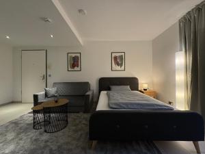 ein Schlafzimmer mit einem Bett und einem Sofa in der Unterkunft Schwarzwaldblick by Rabe - Netflix & Kaffee-Bar & Parkplatz in Karlsruhe
