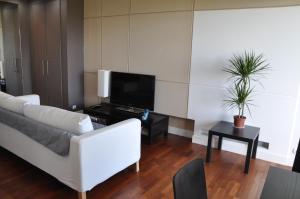 a living room with a white couch and a tv at Apartament Mokotow in Warsaw