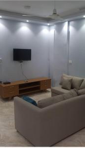 sala de estar con sofá y TV de pantalla plana en Ikea flat 8, en Hurghada