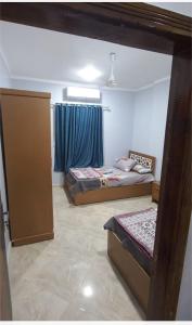1 dormitorio con 2 camas y una ventana con cortinas azules en Ikea flat 8 en Hurghada
