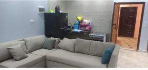 a living room with a white couch with pillows at Ikea flat 8 in Hurghada