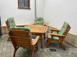 three chairs and a wooden table and two chairs at Ferienwohnung Pütz in Saarburg