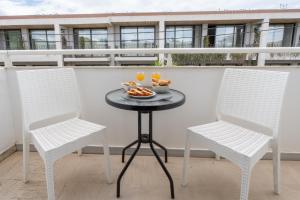 two chairs and a table with a plate of food on a balcony at Bellisimo studios in Zakynthos