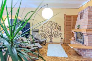 a living room with a brick fireplace and a tree mural at TREE House-Old Town Brașov in Braşov