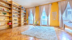 a living room with bookshelves and a rug at TREE House-Old Town Brașov in Braşov