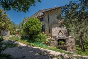 einen externen Blick auf ein Haus mit einem Steinkamin in der Unterkunft Casale Torre Madre in Assisi