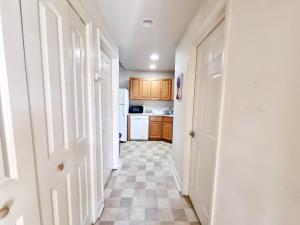 a hallway of a kitchen with a white refrigerator at Lovely Spacious 1br Apt With Patio in Philadelphia