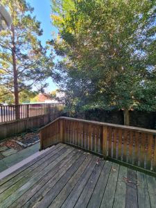 a wooden deck with a fence and trees at Lovely Spacious 1br Apt With Patio in Philadelphia