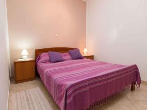 - une chambre avec un lit violet et 2 tables de chevet dans l'établissement Apartments in Crikvenica 5669, à Crikvenica