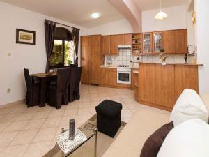 - une cuisine avec des placards en bois et une table dans l'établissement Apartments in Crikvenica 5669, à Crikvenica