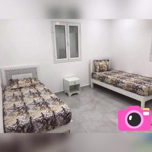 1 Schlafzimmer mit 2 Betten, einem Stuhl und einem Fenster in der Unterkunft Villa Bacha in Houmt Souk
