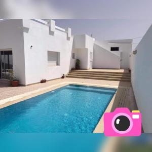 a swimming pool in the backyard of a house at Villa Bacha in Houmt Souk