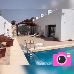 een villa met een zwembad en een huis bij Villa Bacha in Houmt Souk