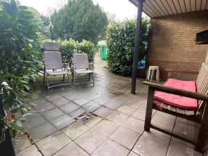 two chairs and a table on a patio at Zonnig appartement met terrasje in Groesbeek