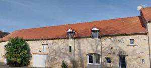 een oud stenen gebouw met een rood dak bij Le Domaine de Bella in Dangé