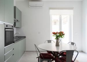 a white kitchen with a table with a vase of flowers at @uRhOME - Luxury Accommodation in Rome