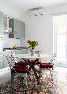 a white kitchen with a table and chairs at @uRhOME - Luxury Accommodation in Rome