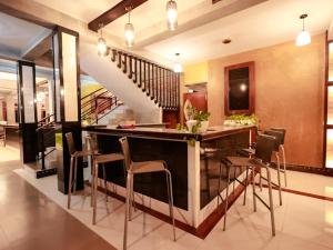 uma cozinha com um bar com cadeiras e uma escadaria em Aramya em Kitulgala