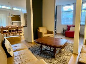 a living room with a couch and a table at Zonnig appartement met terrasje in Groesbeek
