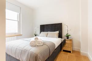 a bedroom with a large bed with two towels on it at Soho - Central London - CityApartmentStay in London