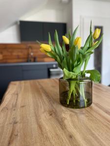 um vaso com flores amarelas sentado numa mesa em Mellie`s Ferienwohnung Willingen em Willingen