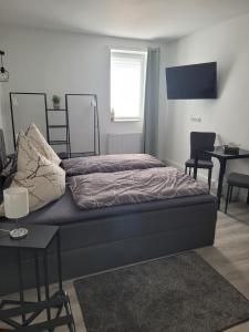 Schlafzimmer mit einem Bett, einem Tisch und einem Fenster in der Unterkunft Airbnb, moderne, ruhige und helle Doppelzimmer, nähe Magdeburg, A14 & A2 in Dahlenwarsleben