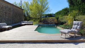 una pequeña piscina con 2 sillas en una terraza de madera en Clos Baroanni - Gîte Terra en Terraube