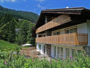 ein großes Haus mit einem Balkon und Bäumen in der Unterkunft Berghaus Anna Lisa in Mittelberg