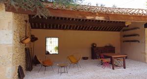 un patio con sillas, una mesa y una ventana en Clos Baroanni - Gîte Terra en Terraube