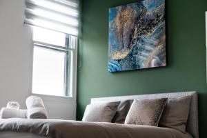 uma sala de estar com um sofá e uma pintura na parede em Cross Street Suites by DH ApartHotels em Peterborough