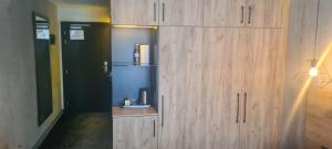 a large wooden cabinet in a room with a refrigerator at Czarna Perła Apartamenty Czarna Góra 103 in Sienna +8 photos