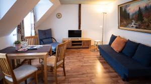 ein Wohnzimmer mit einem Tisch und einem blauen Sofa in der Unterkunft Hotel Royal in Monschau
