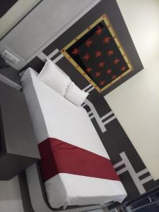 a bedroom with a bed with a red and white blanket at HOTEL R K RESIDENCY MUZAFFARPUR in Muzaffarpur