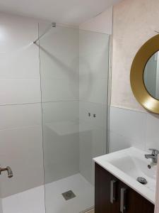 La salle de bains est pourvue d'une douche, d'un lavabo et d'un miroir. dans l'établissement CASA CON TERRAZA, BARBACOA y WIFI PARA 7 PERSONAS, à Ayamonte