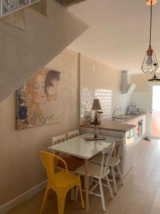 uma cozinha com uma mesa e cadeiras amarelas em CASA CON TERRAZA, BARBACOA y WIFI PARA 7 PERSONAS em Ayamonte